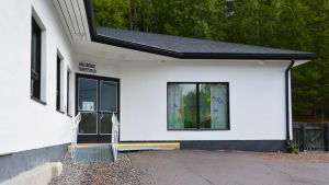 Forsbybor och majoriteten i grundtrygghetsnämnden vill att Forsby hälsogård ska få fortsätta sin verksamhet. En vit byggnad med svarta detaljer. Ovanför ingången står det hälsogård terveystalo.