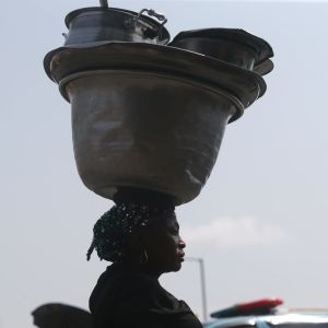En kvinna som säljer mat på gator i Lagos, Nigeria, bar på sina kärl där den 9 mars. 