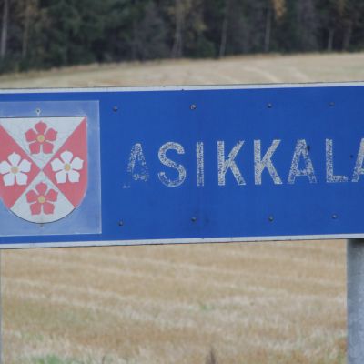 Asikkalan kunnan kyltti pellolla.