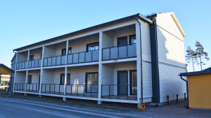 Det här bostadshuset, som ligger mittemot Majbergets servicehem, är både tomt och halvfärdigt. Ett vitt tvåvåningshus med flera bostäder invid en gata.