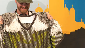 Rolf Ekroths kläder är inspirerade av idrottskläder. "Färggrannt, sporttyger, jag blandar olika tyger och syr ihop dem på intressanta sätt." Designstuderande Rolf Ekroth håller upp en av sina kreationer.