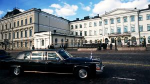 Suomenlipulla varustettu auto presidentinlinnan edustalla