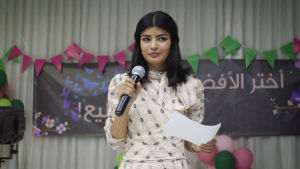 Maryam (Mila Al Zahrani) ordnar sin valkampanj genom att googla fram råd på nätet. Närbild på Maryam (Mila Al Zahrani) då hon står på scen och håller ett tal.