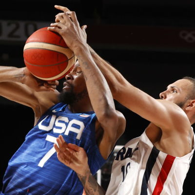 Kevin Durant i blå tröja får bollen i ansiktet i en duell med Evan Fournier i vit blus.