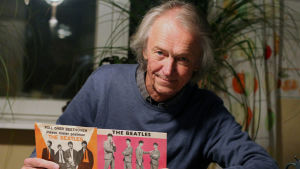 Folke West vurmade för The Beatles som dj. Folke West sitter vid ett köksbord och visar i två beatlessinglar
