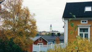 Oulu on Kinnuselle tärkeä paikka. Siellä hän on kasvanut, kouluttautunut ja kohdannut elämänkumppaninsa. Tähän maisemaan hän ei kyllästy koskaan. Syksyinen näkymä oululaisessa puutalokorttelissa. Horisontissa näkyy kirkon torni.