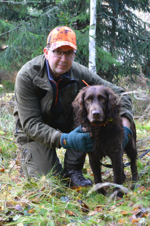 För Magnus Nylander och Choko har det blivit otaliga timmar tillsammans i skogen. Magnus Nylander iklädd gröna jaktkläder sitter på huk tillsammans med Choko.