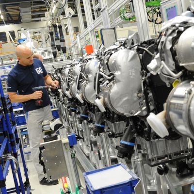 En Volkswagenanställd jobbar med dieselmotorer i en fabrik i Tyskland. 