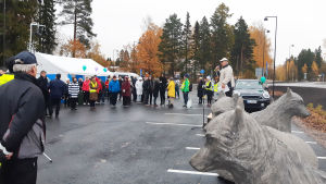 Nickbyborna var inte rädda för lite regn. Besökare kom och gick flitigt under hela kvällen. En folksamling står runt några grå vargstatyer. Bredvid statyerna står en man som talar i en mikrofon.