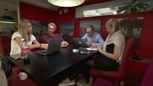 Qasvu är ett av företagen i Hanken Business Lab. Jonas Tommila (andra från vänster) är en av företagets grundare. Några unga personer sitter runt ett bord, väggarna är röda.