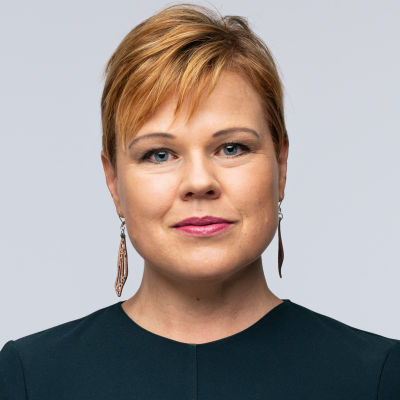 profilbild Ingemo Lindroos, grön blus, kort hår med lugg, tittar i kameran