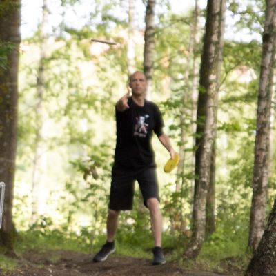 Mies puttaa frisbeegolf-kiekkoa