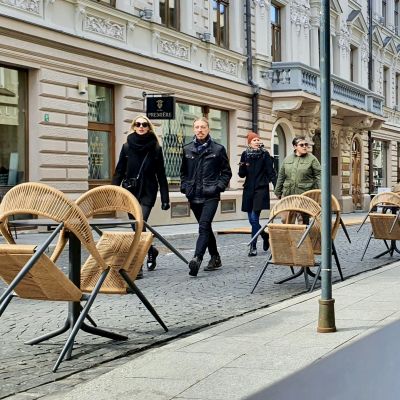 Flera par kommer vandrande emot på en gågata i Vilnius i Litauen med coronasäkerhetsavstånd mellan paren.
