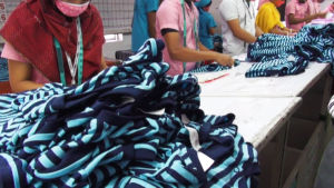 Työläiset tarkastavat paitoja bangladeshilaisessa vaatetehtaassa.