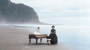 Piano. Nainen ja tyttö ja piano autiolla rannalla. Kuva elokuvasta Piano.