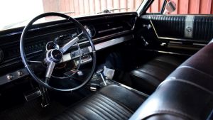 Svart, svart, svart som natten inne i bilen. Svart läderinteriör på en klassisk chevrolet impala från 1965