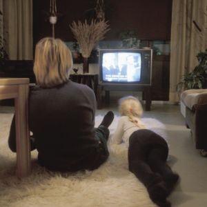 Nainen ja lapsi katsovat televisiota olohuoneen lattialla. Kuva otettu vuonna 1983.