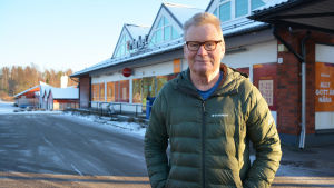 Johan Funck är samtidigt trött på och nöjd med att inget händer. En man i grön dunjacka står utanför en matbutik i ett snöigt landskap. Han har händerna i fickorna och tittar in i kameran.