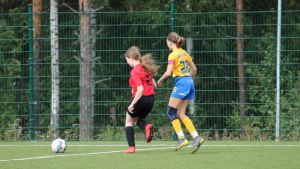 Elin Ahrenberg (i gul skjorta) spelar som anfallare i IIF Fotbolls F06-lag. Elin Ahrenberg täcker en motståndare som har bollen.