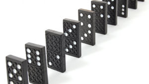 Orsak och verkan. En dominobricka faller, får en annan bricka att falla, och så vidare. Dominobrickor.