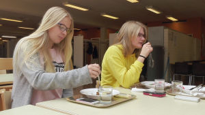 Maya Parkkinen (till vänster) och Maria Söderbacka äter skollunch. Maya skulle hellre äta mat som är tillagad samma dag. Maya Parkkinen äter grönsaksbiffar i Oxhamns skola i Jakobstad.