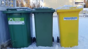 Muovin, paperin ja kartongin keräysastiat omakotitalon pihassa.