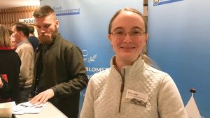 Freya Roe kan tänka sig att stanna på Åland så länge det finns jobb för henne där. Freya Roe framför en skylt med texten "Ålands landskapsregering".