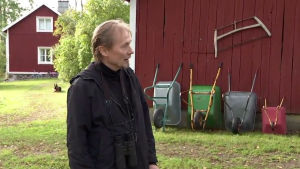 Riggert Munsterhjelm på gården i Snappertuna. Man i förgrunden, i bakgrunden röda hus och skottkärror.
