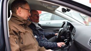 Mats Nurmio bekantar sig med bilförsäljaren Jan-Erik Lindbloms gasbil. Mats Nurmio och Jan-Erik Lindblom sitter och pratar inne i en gasbil.