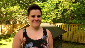 Annika Röjdahl säger att hon vuxit som människa med den här utbildningen och att den varit en personlig resa för henne personligen. en kvinna i kort hår och svarblommig klänning i somrigt väder med grönska runtomkring