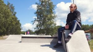 Karis och Ekenäs kan ibland konkurrera med varandra menar Simon Andersson. Man i sportkläder sitter vid en skejtramp. I bakgrunden träd.