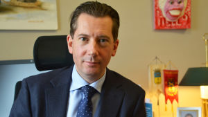 Stadsdirektör Jan D. Oker-Blom var den som ville utreda hur mycket kommuninvånarnas begäran om information kostar staden i arbetstimmar. En man i kostym sitter på en skrivbordsstol. Bakom honom syns tavlor och vimplar.