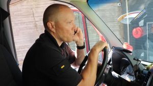 Marko Lassila har jobbat som djurräddningsansvarig i ett par år. En skallig man sitter och pratar i telefon bakom ratten på en parkerad bil.