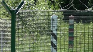 Bakom gränsstaketet syns en estnisk och en rysk gränsstolpe. Den tio meter breda gränszonen är alltså på den estniska sidan av gränsen. Bakom gränsstaketet syns en estnisk och en rysk gränsstolpe.