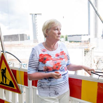 Marja Vuorilehto seisoo rakennustyömaan edustalla.