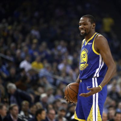 Kevin Durant hymyilee kentällä.