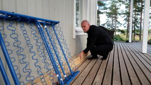 Det finns ännu en hel del småsaker som ska fixas på huset och på gården, Richard hoppas de ska bli färdiga innan barn nummer två kommer. Richard Palonen lyfter på några bräder på husets terass.