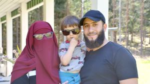 Pernilla Sjögård och Abdul Aki har köpt presenter till sin son Adam Aki för att fira fastans slut Pernilla Sjögård i vinröd burka och med glasögon på och Abdul Aki i svart t-skjorta och keps håller i sin son Adam Aki i grå tröija med bilar på och solglasögon på.