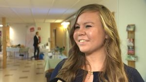 Erica Helin från Pargas är mer vänsterorienterad. Erica Helin ler i tv-sändning. I bakgrunden syns ett rum med en man.
