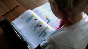 Tyttö lukee oppikirjaa