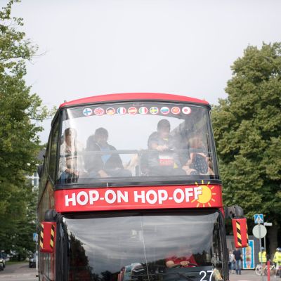 Turisteja kiertoajelubussissa Helsingissä.