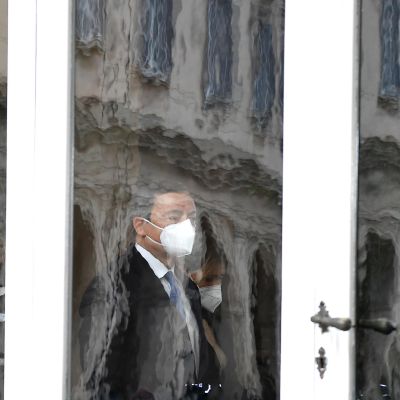 Mario Draghi ikkunalasin takana hengityssuoja kasvoillaan.