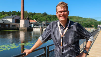 Porträtt av Ville Vuorelma som poserar mot broräcket på en bro i Svartån.