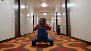 Danny (Danny Lloyd) i The Shining och med något hemskt väntande bakom nästa hörn. Och den kännspaka orangebruna golvmattan med hexagonmönster. En liten pojke kör med en trampcykel i en tom hotellkorridor.