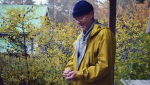 Kristian Lindroos säger att vissa söker original, andra söker bekvämlighet. Kristian Lindroos med några nycklar i sin hand. Han har en gul rock på sig i ett gult och grannt höstlandskap.