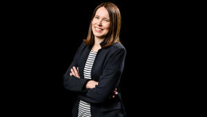 Katri Vataja säger att det finns tre stora trender som man kommer prata om i år. Kvinna med brunt hår. Ler och håller armarna i kors och tittar in i kameran. Hon står framför en helfärgad, svart bakgrund.