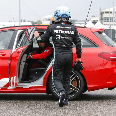 Valtteri Bottas vandrar mot ett öppet baksäte i en bil.