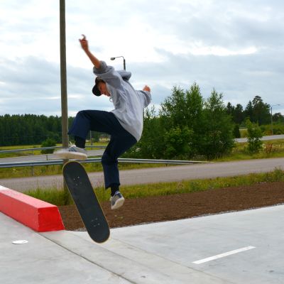 Ung pojke hoppar i luften från skateboard
