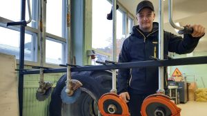 Jonas Westerholm tror starkt på att det finns arbeten inom skogsbranschen. Jonas Westerholm står i en hall med en röjsåg.