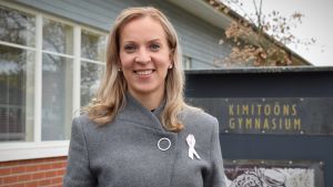 Sandra Bergqvist sysslade omedvetet med politik redan i gymnasieåldern. Sandra Bergqvist iklädd en grå rock står framför kimitoöns gymnasieskola, en låg, röd teglbyggnad.